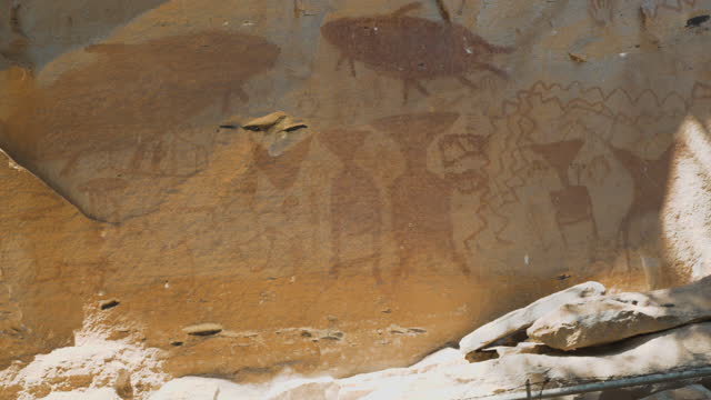 Rock art Stone carving art of humans, animals and handprints covering the cliffs in Ubon Ratchathani, Thailand.