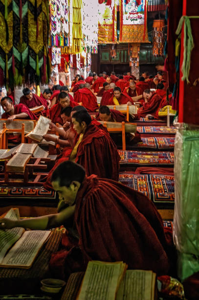 Tibetan buddhist monks reading holy books and praying in a monastery stock photo
