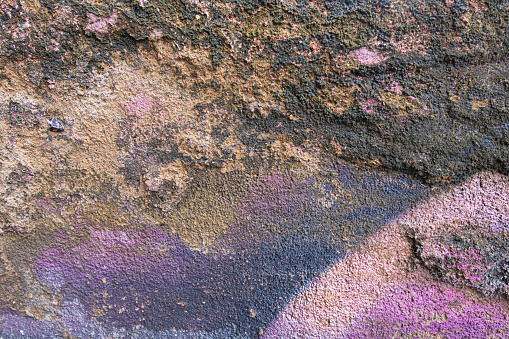 Concrete wall with pink and purple hues background and wallpaper texture