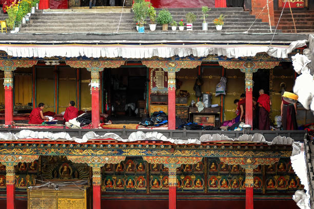Lhasa, Tibet - September 1, 2007: Tashilhunpo monastery some monks are seated in company under the arcades of the temple