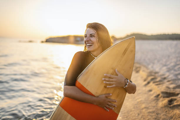 istock Surfer woman at sunset 1458137370