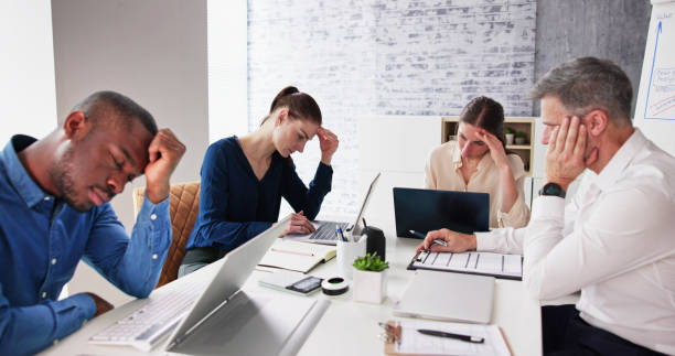 istock Bored Male Manger Sitting With His Colleagues 1458140387