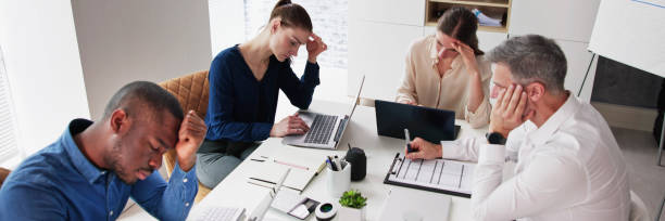 istock Bored Male Manger Sitting With His Colleagues 1458140403