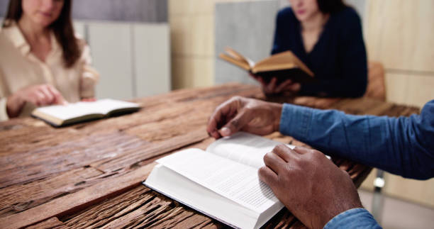 istock Young Multiethnic People Reading Bible Over Wooden 1458141495