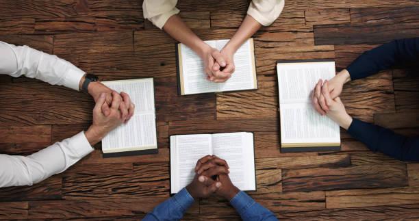 istock Elevated View Of People Reading Holy Books 1458141549