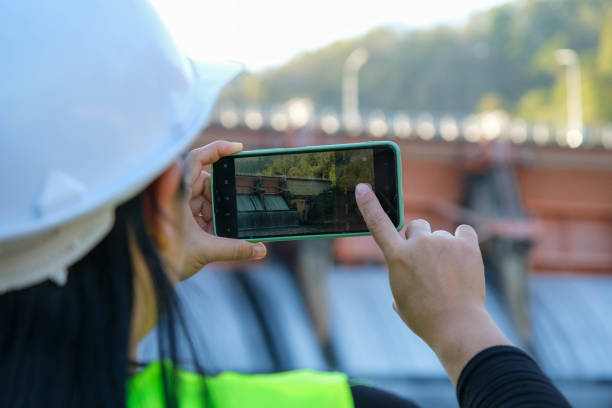 istock Environmental engineers use mobile phones to take pictures and record data analyzing dam water contaminants. Water and ecology concept. 1458143504