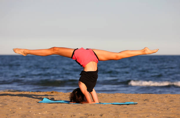 girl does exercises on the beach by the sea