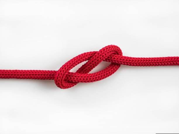 red rope knot closeup of a red rope knot on a white background roped off stock pictures, royalty-free photos & images