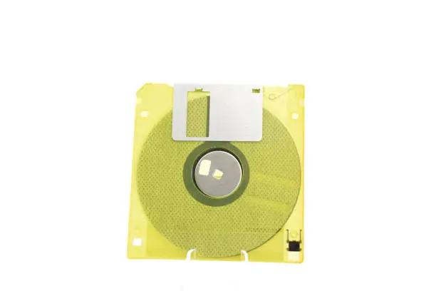 Photo of The image shows a yellow, translucent retro floppy disk with a capacity of 1.44 megabytes (megabytes) on a white background.