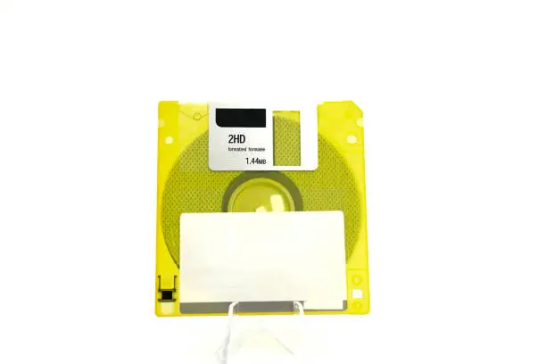 Photo of The image shows a yellow, translucent retro floppy disk with a capacity of 1.44 megabytes (megabytes) on a white background.