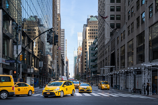 New York, USA - April 22, 2019:  Yellow taxi cabs speeding in Midtown Manhattan, New York City, United States.