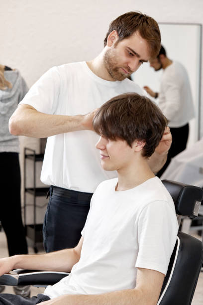 istock Barber talking to caucasian man while sitting in chair 1458157471