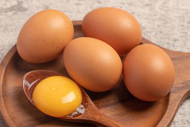 istock Fresh chicken eggs in a wooden plate 1458157700
