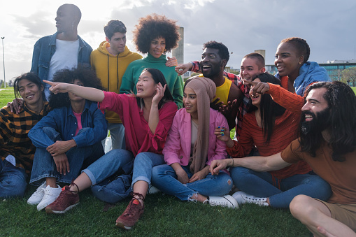 group of different ethnicities enjoying outdoors and pointing to another place