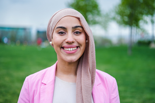 portrait of young woman wearing hijab and smiling. happy outdoors