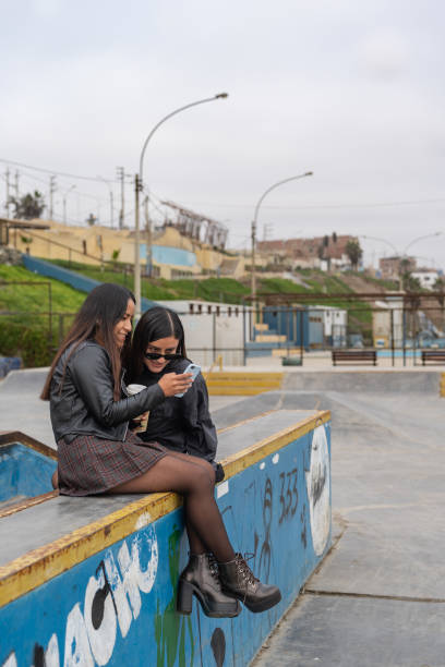 istock Two young women using a mobile in an urban park 1458162235