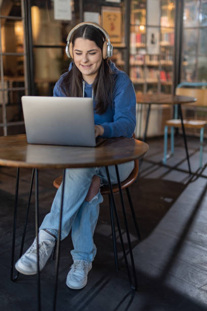 istock Female student using laptop in University lobby 1458164022