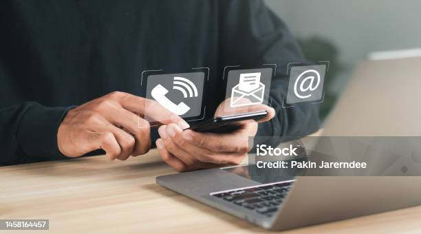 Businessman Using Laptop And Smartphone With Contact Icons On Virtual Screen Searching Web Browsing Information Contact Us Or Customer Support Hotline People Connect Stock Photo - Download Image Now