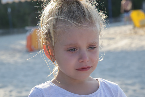 Outdoor portrait of upset crying little girl