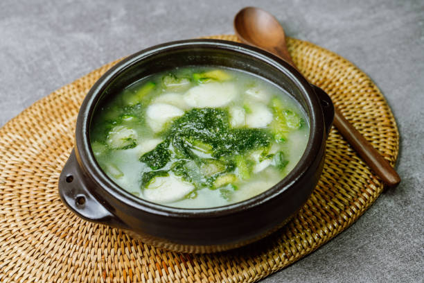 Tteokguk, Korean Seaweed fulvescens Sliced Rice Cake Soup : Oval-shaped rice cake cooked in broth. A traditional Lunar New Year dish. Clear beef broth is most commonly used, but chicken or seafood may be added. tteokguk, korean seaweed fulvescens sliced rice cake soup : pastel de arroz de forma ovalada cocinado en caldo. un plato tradicional del año nuevo lunar. el caldo de carne clara es el más comúnmente utilizado, pero se puede agregar pollo o mariscos.