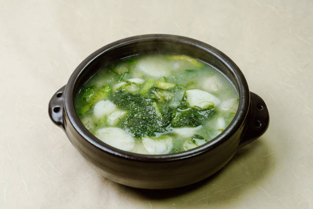 Tteokguk, Korean Seaweed fulvescens Sliced Rice Cake Soup : Oval-shaped rice cake cooked in broth. A traditional Lunar New Year dish. Clear beef broth is most commonly used, but chicken or seafood may be added. tteokguk, korean seaweed fulvescens sliced rice cake soup : pastel de arroz de forma ovalada cocinado en caldo. un plato tradicional del año nuevo lunar. el caldo de carne clara es el más comúnmente utilizado, pero se puede agregar pollo o mariscos.
