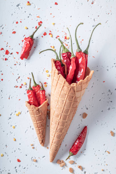 istock Spicy ice cream concept. Chilli peppers in ice cream cone. 1458169381