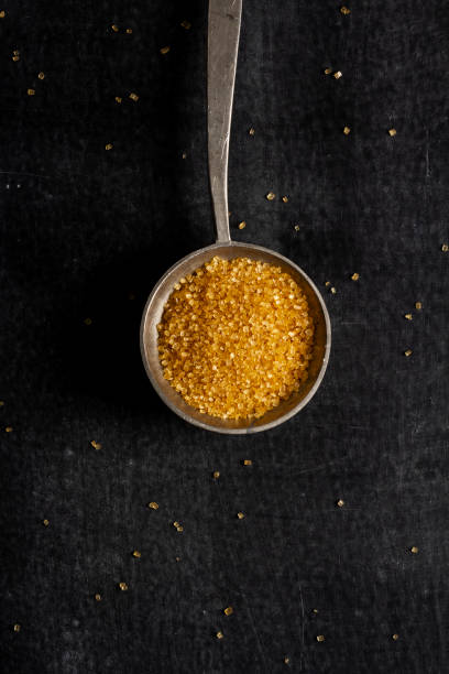 istock Big old spoon with brown sugar on black background 1458178935