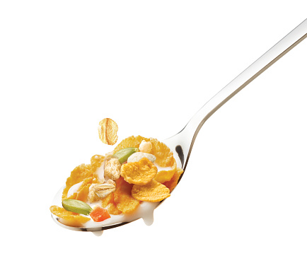 cereal on a silver spoon, on white background