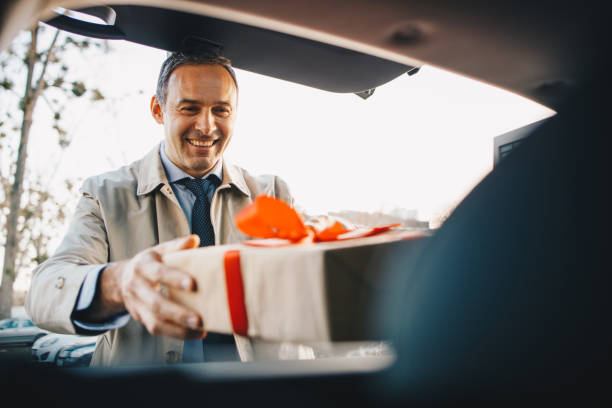Loading car trunk with Valentines gift. stock photo