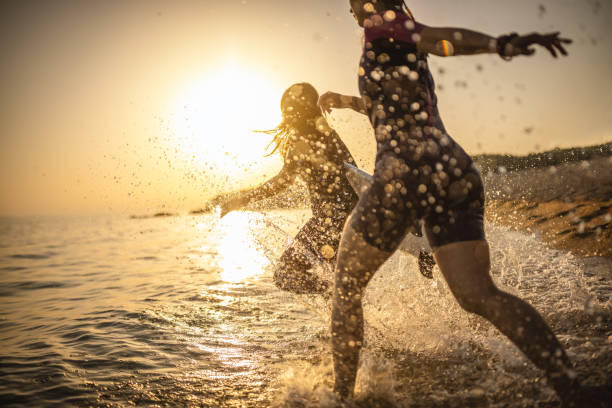 istock Surfers running into the sea with their surfboards 1458184127