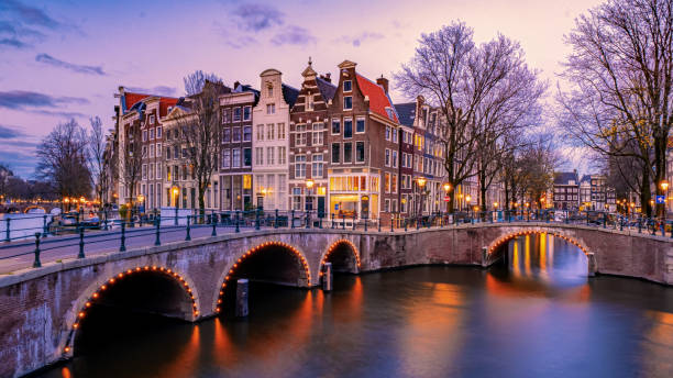 amsterdam di notte con la casa colorata danzante ai canali di amsterdam - amstel river foto e immagini stock