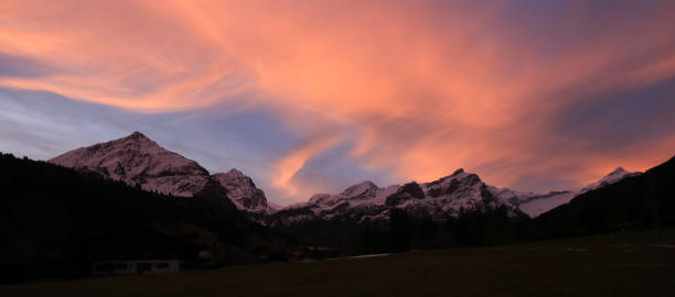 cielo mattutino dipinto su una catena montuosa a gsteig bei gstaad. - bernese oberland gstaad winter snow foto e immagini stock