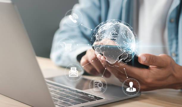istock Businessman using laptop and smartphone with E-commerce technology on virtual global network. High tech and big data concept. Global connectivity, Internet of Things (IOT). 1458191116