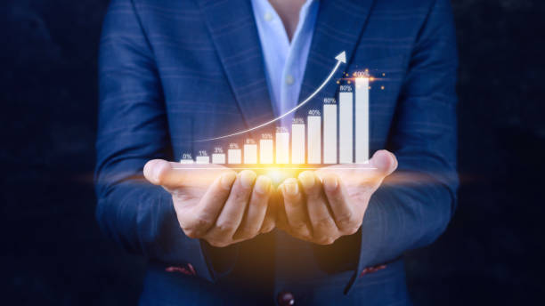 istock Businessman showing business growth on graph Hands touching graphs representing increasing profits, financial symbols coming 1458192744
