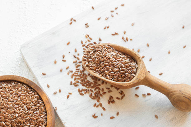 Heap of Flax seeds or linseeds in spoon on rustic background. Flaxseed concept, dietary fiber background stock photo