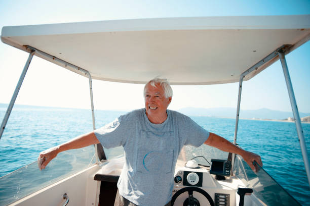 istock Smiling Senior Man sailing his boat on a sunny day 1458195962