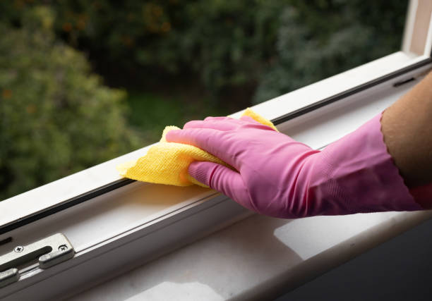 istock Hand holding a yellow microfiber cloth to clean dust on a window rail 1458198402