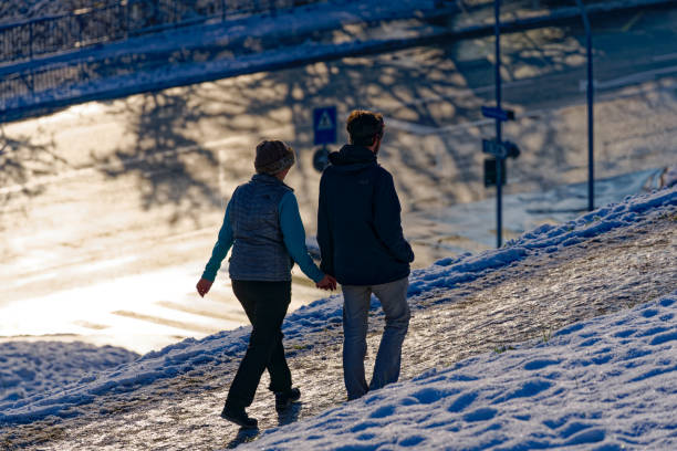 Couple walking on snow covered footpath at City of Zürich on a sunny late autumn day. Photo taken December 11th, 2022, Zurich, Switzerland.