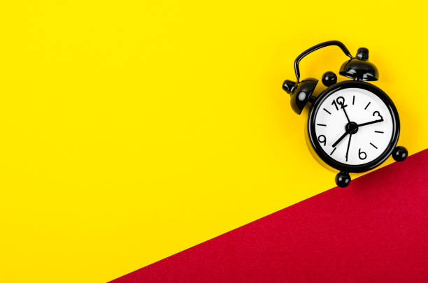 istock A Black vintage alarm clock on yellow and red background with empty space for your text or message. 1458204969