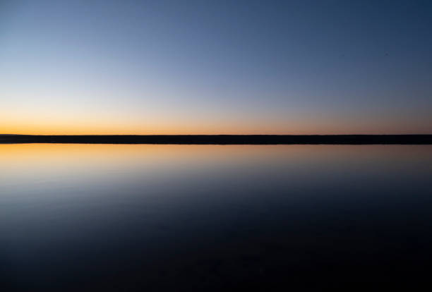 puesta de sol sobre agua quieta - horizon over water england uk summer fotografías e imágenes de stock