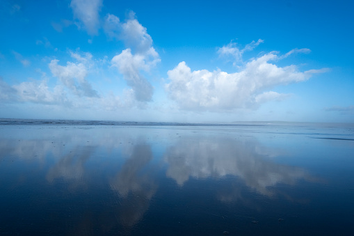 Reflections of summer in the receeding tide on a beach in North Devon