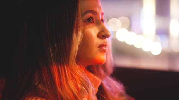 istock Woman driving a car at night, waiting at a red light 1458215575