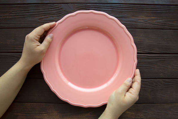 istock Empty pink plate on wooden background. Diet or cooking concept. 1458215679