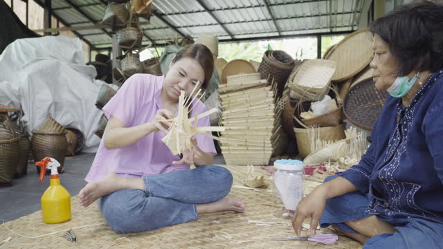 Woman learn weaving bamboo basket, handmade by Villagers from Chiangmai, Thailand.