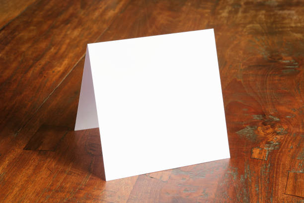 istock Standing blank empty square greeting card template on dark wooden background 1458224306