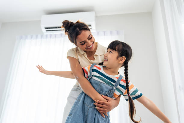 Caucasian happy family, parent spend free time with kid together at home. Adorable young girl daughter hug mother while playing with happiness in living room. Activity relationship in house concept. stock photo