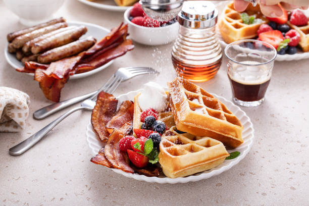 istock Breakfast table with waffles, croissants and bacon 1458229474