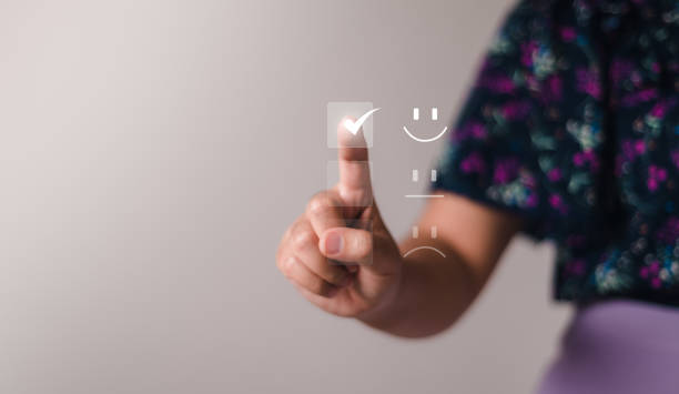 Satisfaction For the Customer service concept, Business people are touching the virtual screen on the happy smile face icon to give satisfaction in service. rating very impressed. stock photo
