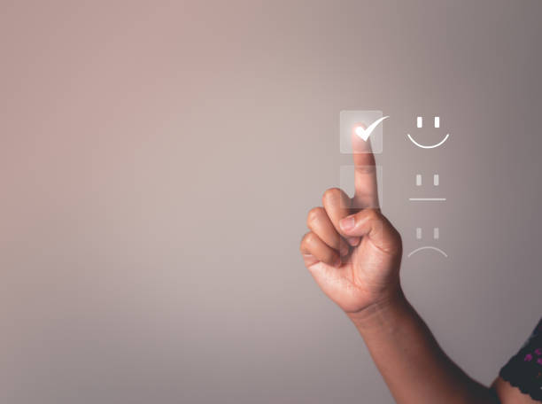 Business people are touching the virtual screen on the happy smile face icon to give satisfaction in service. rating very impressed. Satisfaction For the Customer service concept. stock photo