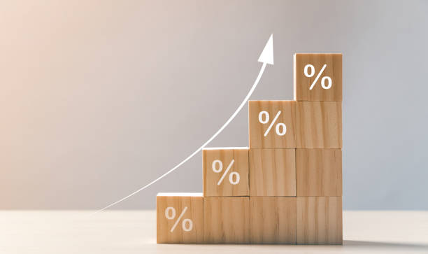 The economy is improving. Interest rate financial and mortgage rates concept. Wooden blocks with Icon percentage symbol and arrow pointing up. stock photo